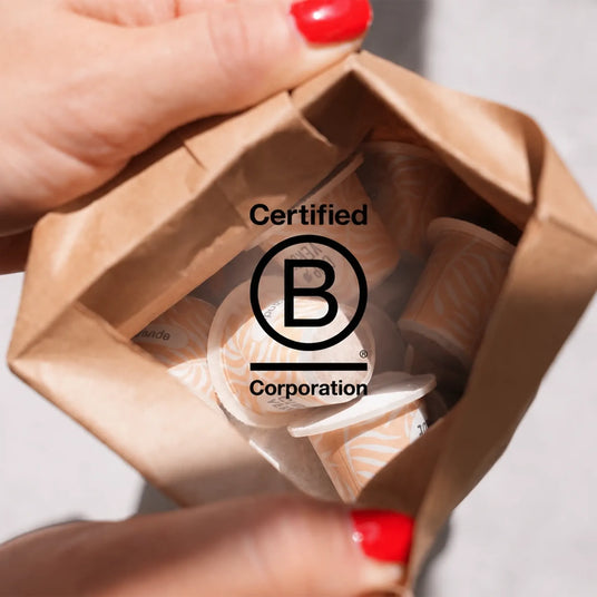 b-corp-tüte-inhalt-hände-kapsel-cup-verde